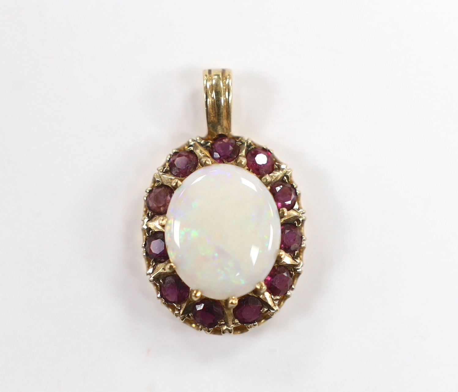A modern 9ct gold, white opal and ruby set oval cluster pendant, overall 28mm, gross weight 3.6 grams.